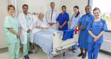 patient at bed alongside with staffs standing